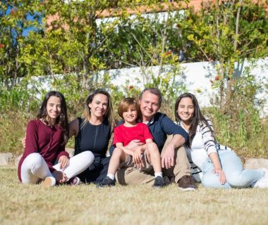 A joyful family enjoying sunny moments in a lush Portuguese garden.